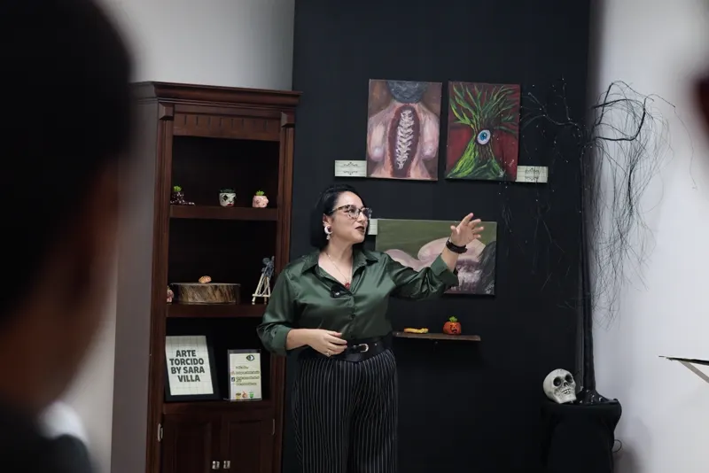 Sara Villa explica sus pinturas frente al muro negro de la sala del CCLEMS